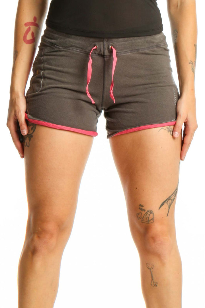 Front view of gray and pink Nike athletic shorts with drawstring waistband and pink trim details