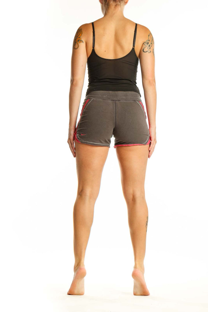 Back view of gray and pink Nike athletic shorts showing side pink accents and athletic fit