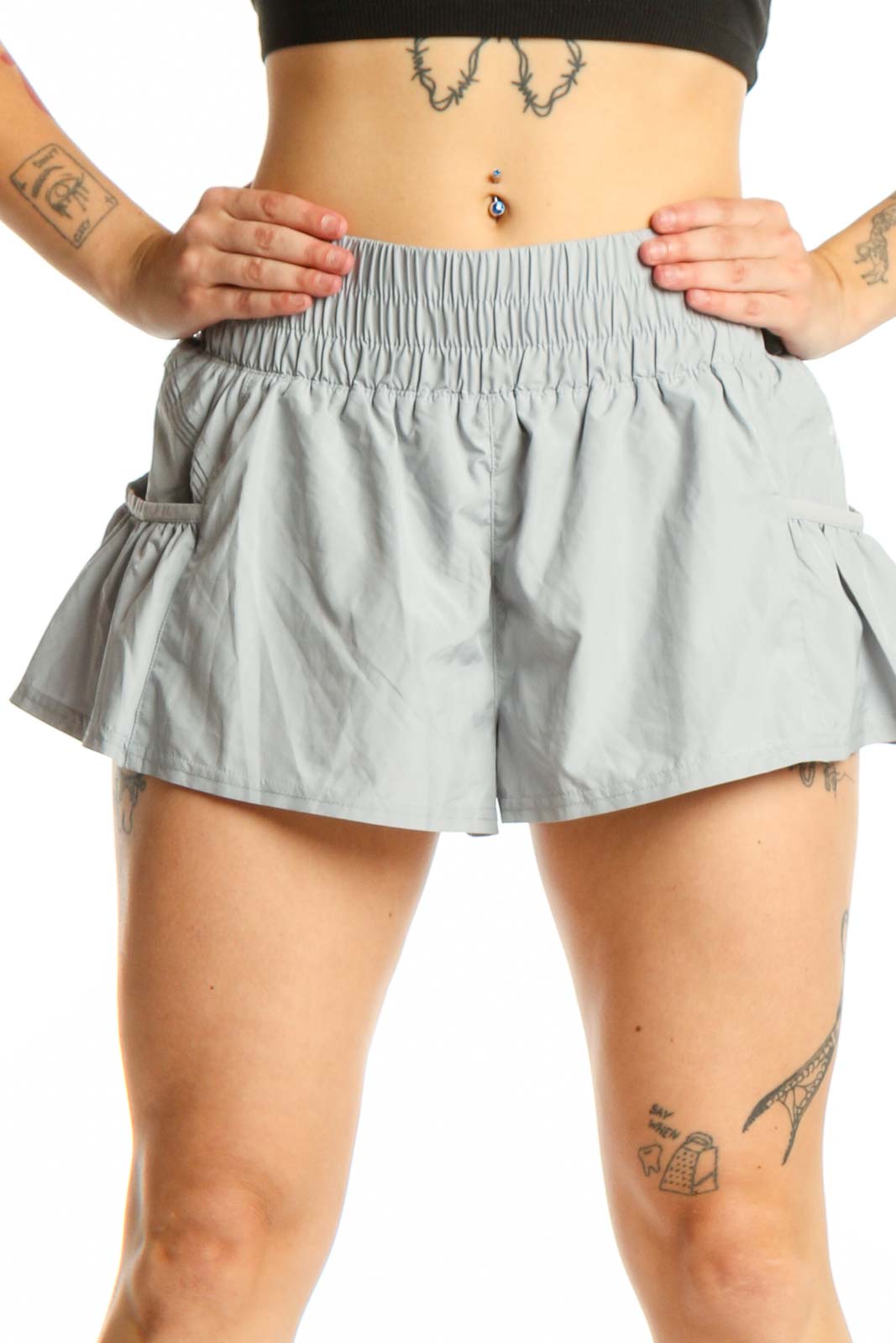Gray ruched athletic skort with side pockets and flared design, front view