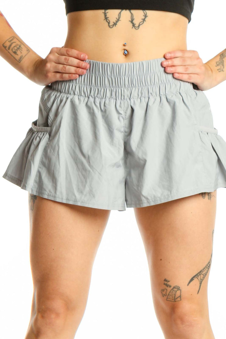 Gray ruched athletic skort with side pockets and flared design, front view