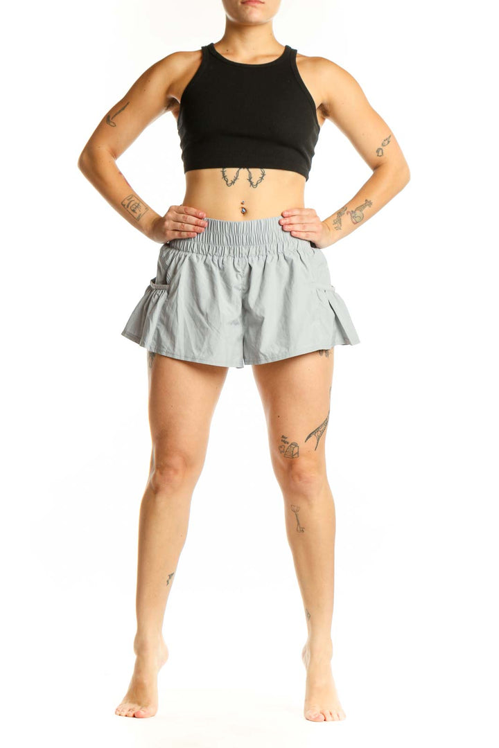 Gray ruched athletic skort with side pockets and flared design, front view