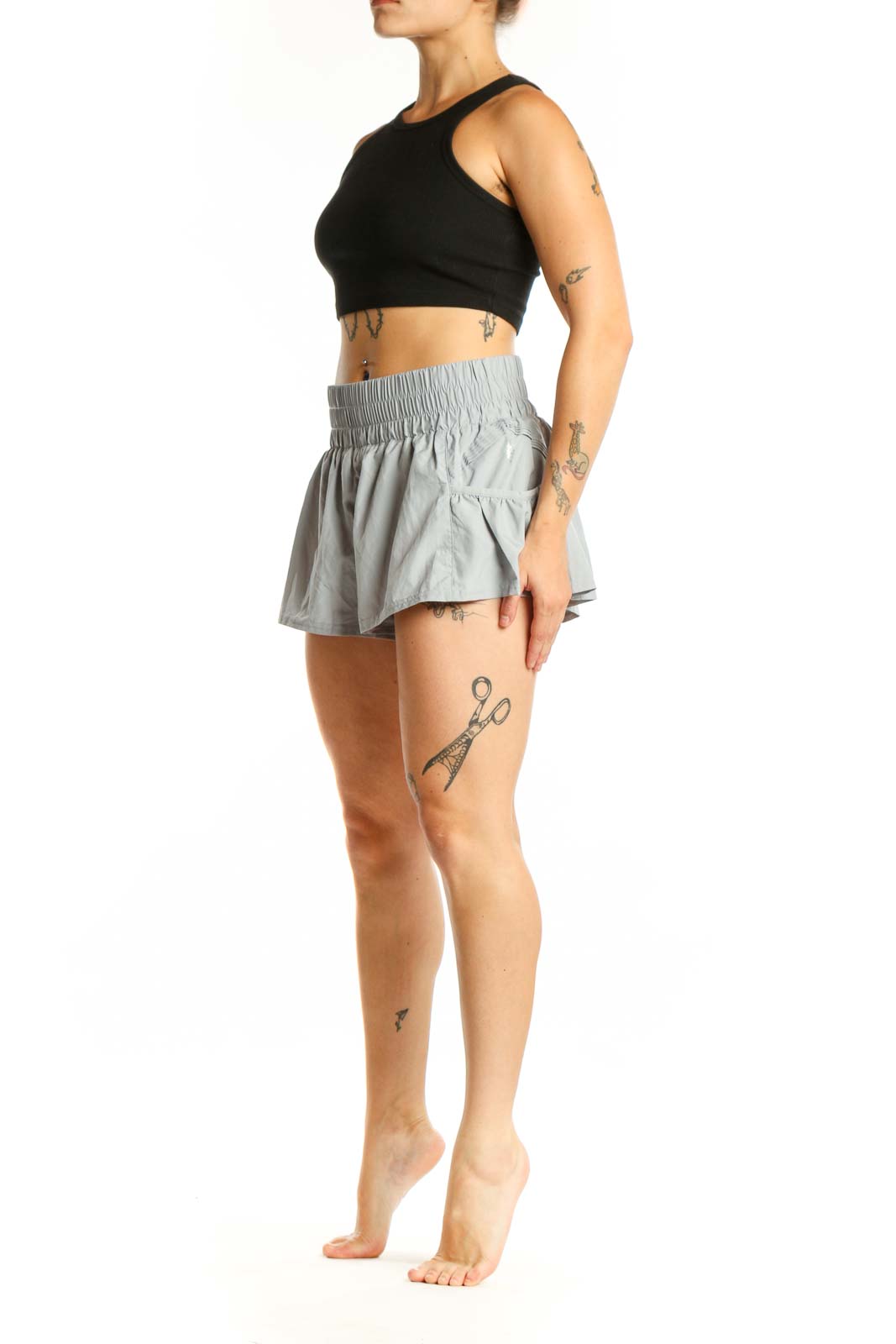 Gray ruched athletic skort with side pockets and flared design, front view