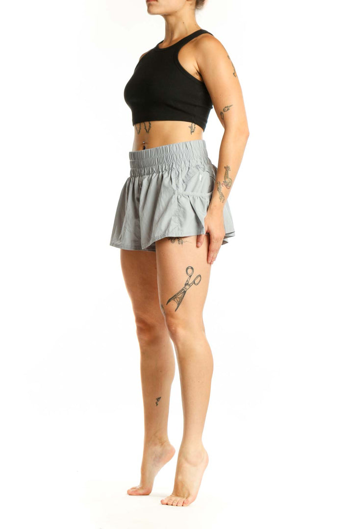 Gray ruched athletic skort with side pockets and flared design, front view