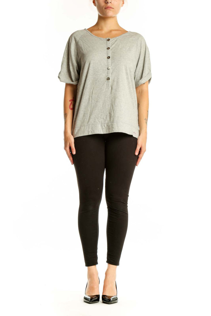 Beige button-front short sleeve top with rolled sleeves, front view on model