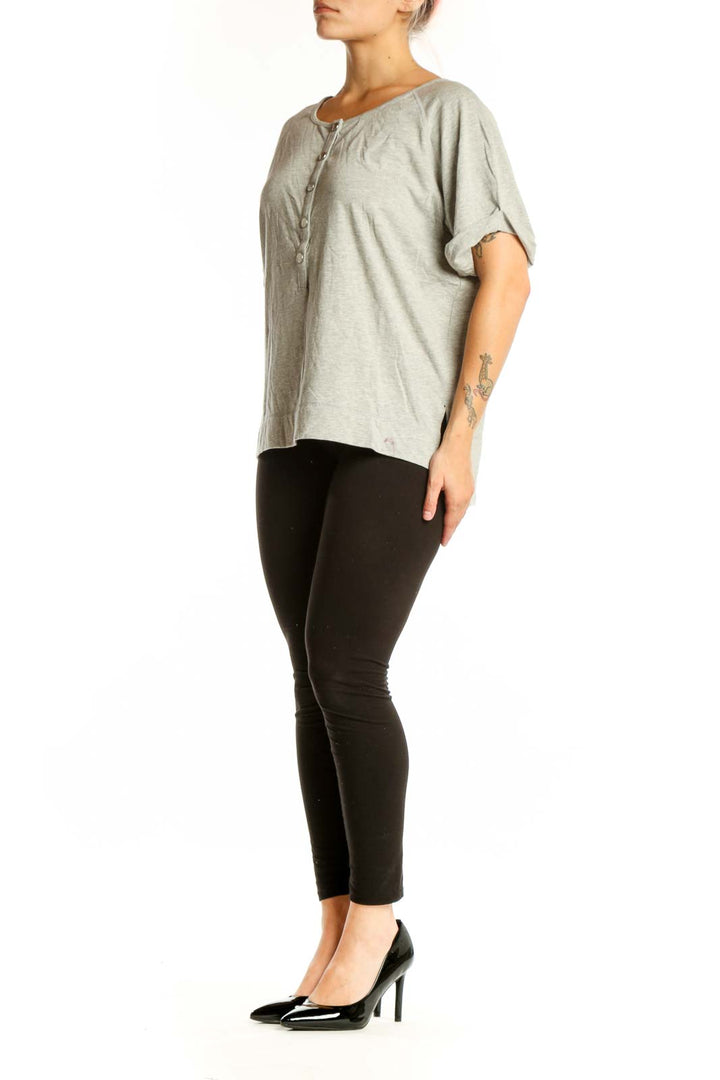 Beige button-front short sleeve top with rolled sleeves, front view on model