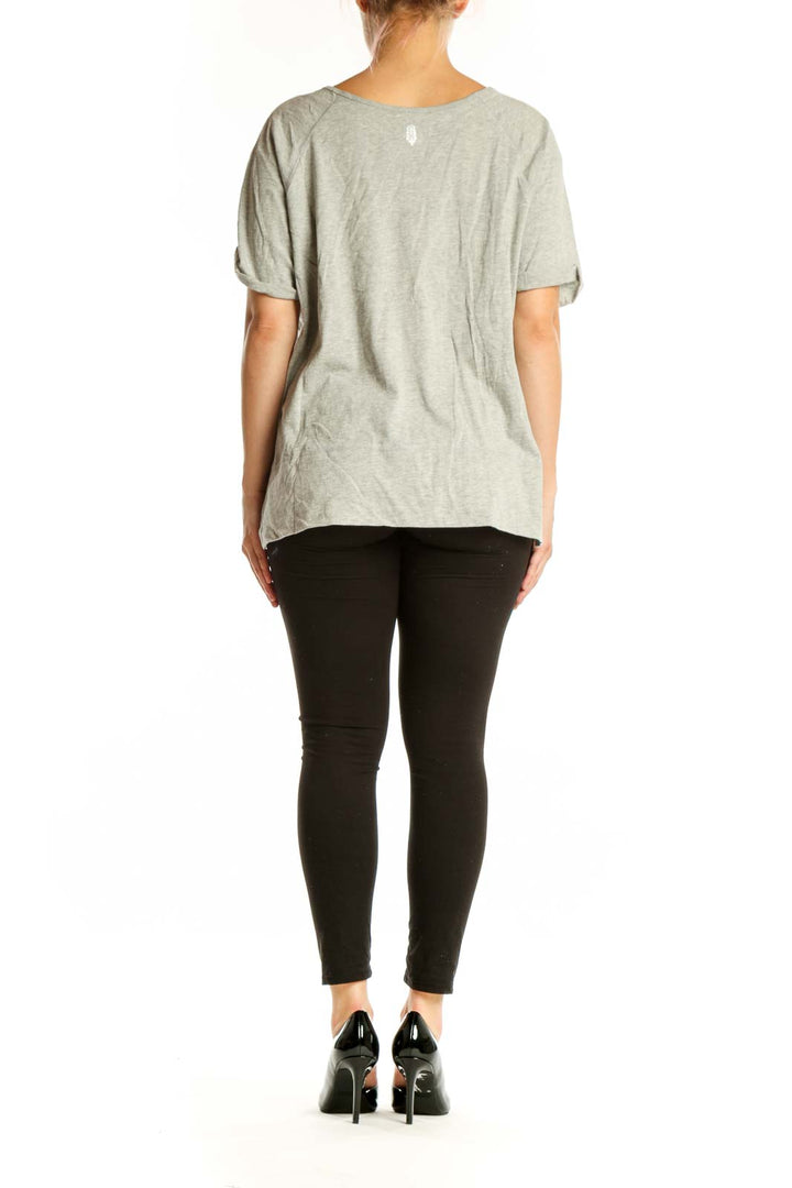 Beige button-front short sleeve top, back view on model showing relaxed fit