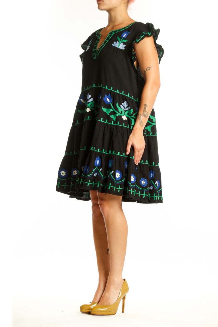 Roller Rabbit black cotton dress with hand-embroidered blue and white floral motifs, tiered silhouette, and flutter sleeves, front view