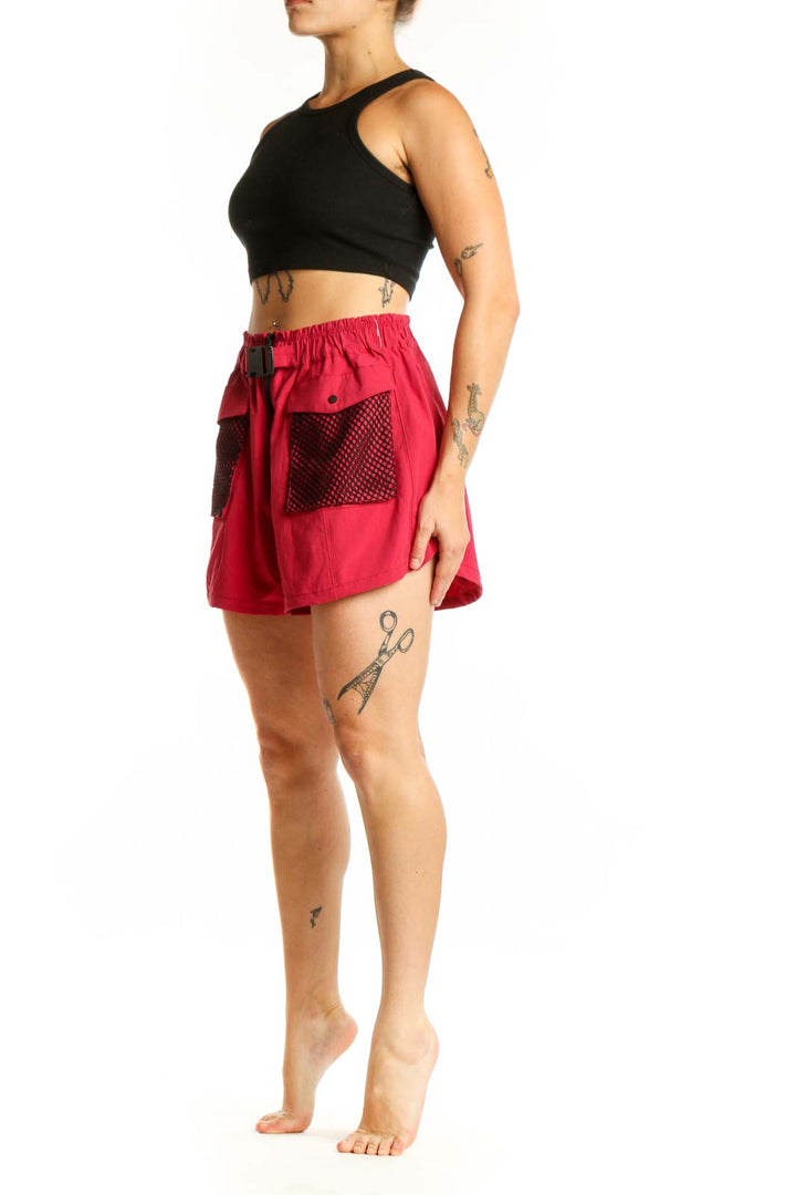 Red athletic shorts with mesh pockets and drawstring waistband, front view