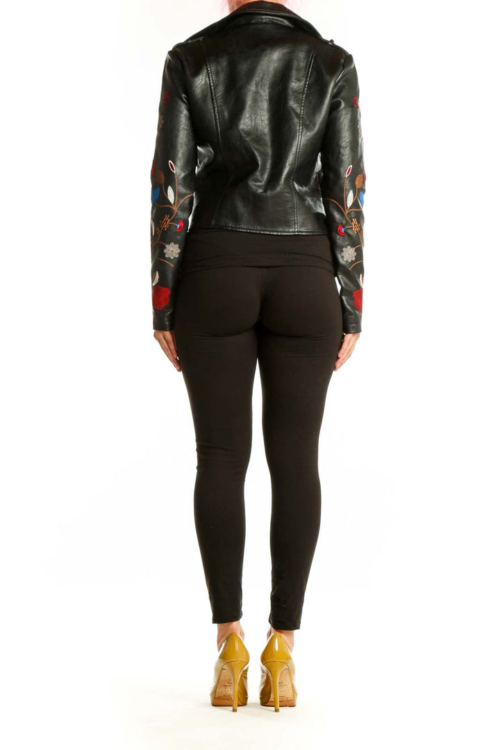 Black studded biker jacket with floral embroidery on sleeves, back view
