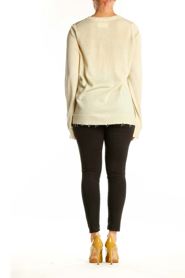 Back view of cream merino wool sweater showing matching skull graphic design