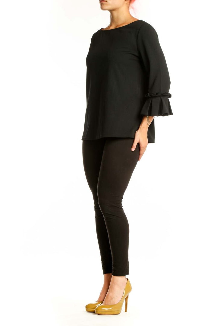 Black ruffle sleeve blouse with boat neckline, front view on model