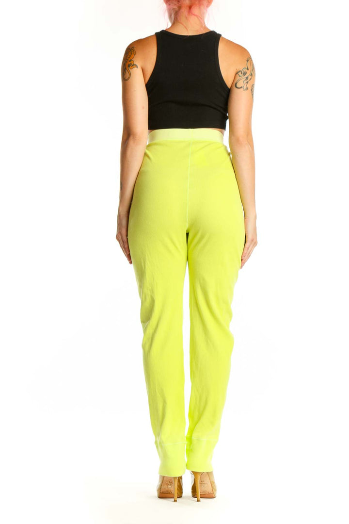 Back view of neon yellow high-waisted stretch pants from Skims showing fitted silhouette