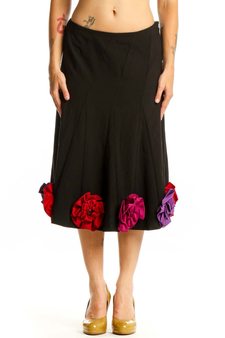 Black flare skirt with red, pink, and purple three-dimensional floral appliqués at hem, front view