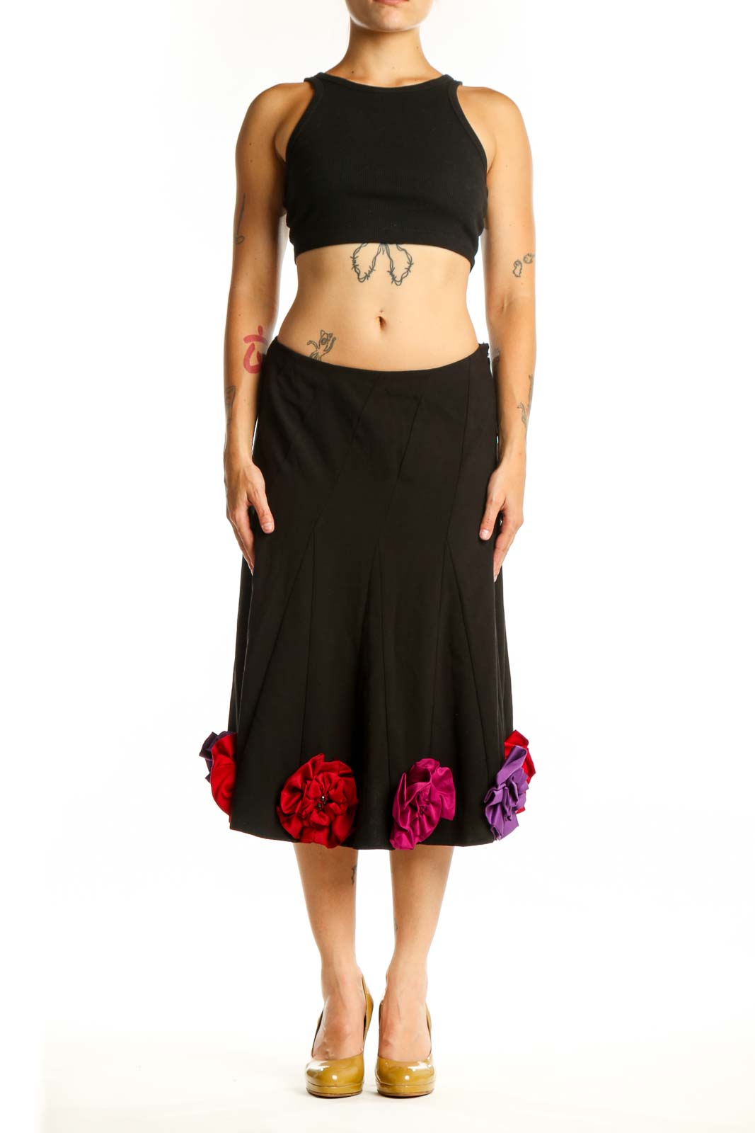 Black flare skirt with red, pink, and purple three-dimensional floral appliqués at hem, front view