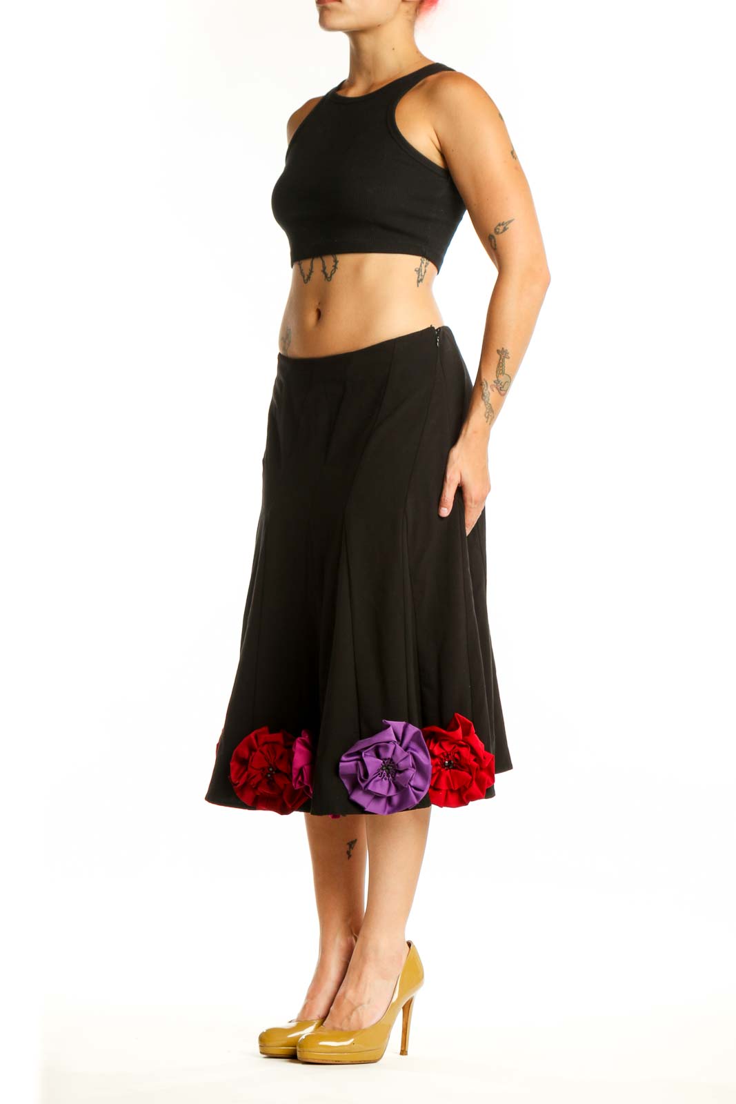 Black flare skirt with red, pink, and purple three-dimensional floral appliqués at hem, front view
