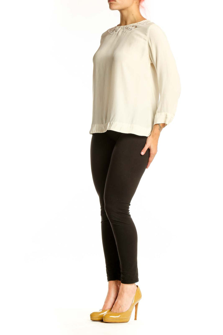 Cream Sandro blouse with lace shoulder trim and three-quarter sleeves, front view