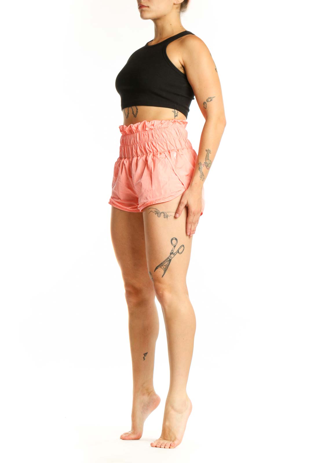 Coral pink ruched athletic shorts with high waistband, front view on model