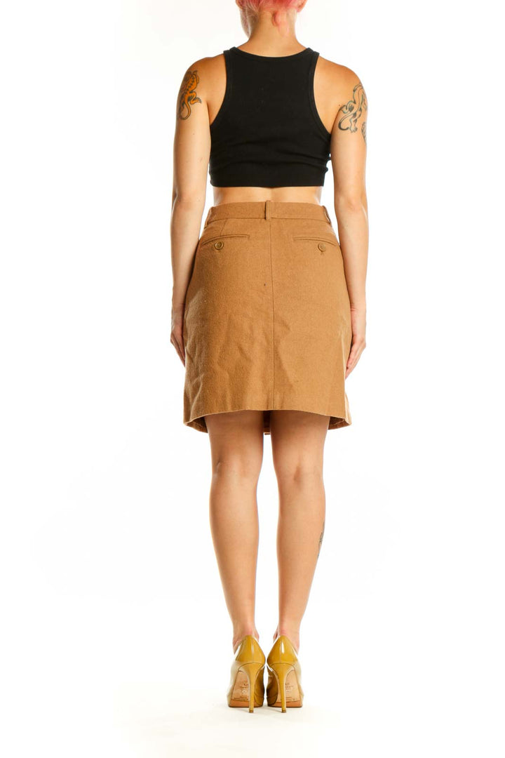 Tan button-front A-line skirt back view showing structured silhouette and button closure