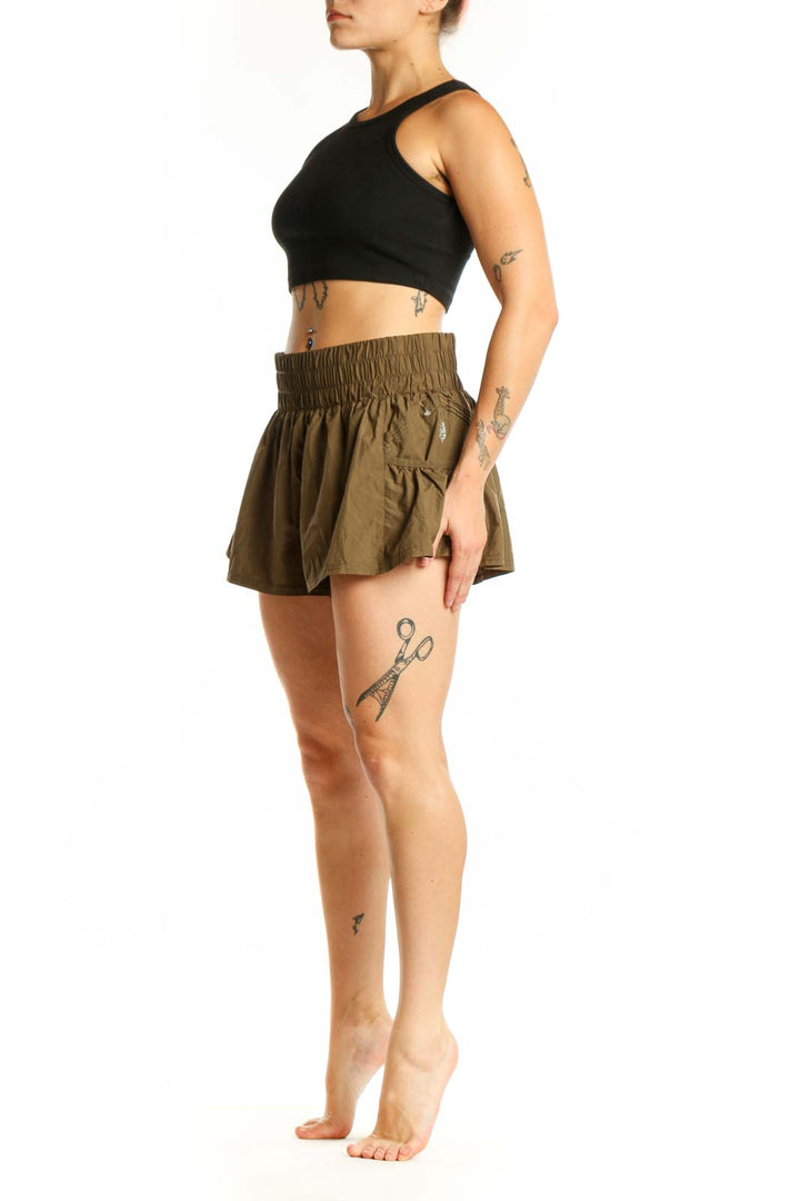 Olive green ruched athletic skirt with elastic waistband, front view showing flowy design and gathered construction