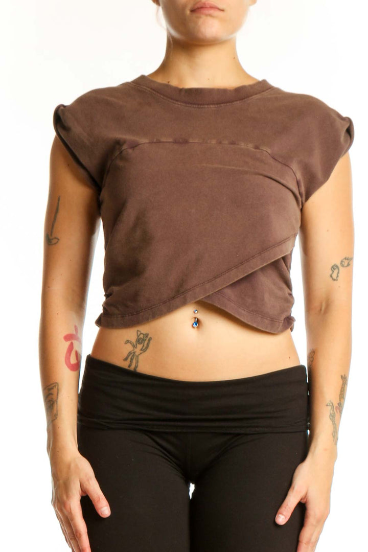 Brown twisted crop tank top with asymmetrical front design, paired with black leggings