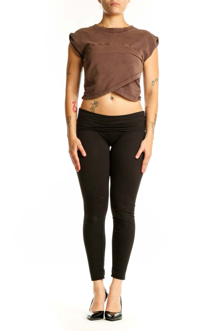 Brown twisted crop tank top with asymmetrical front design, paired with black leggings