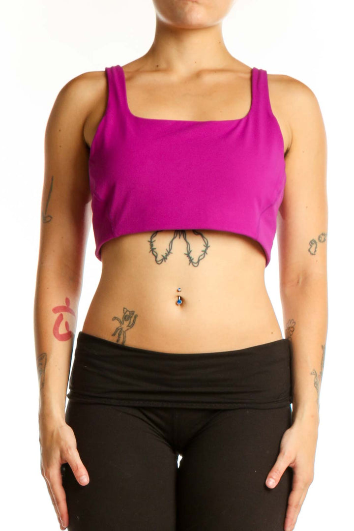 Woman wearing magenta square neckline sports bra with black leggings, front view