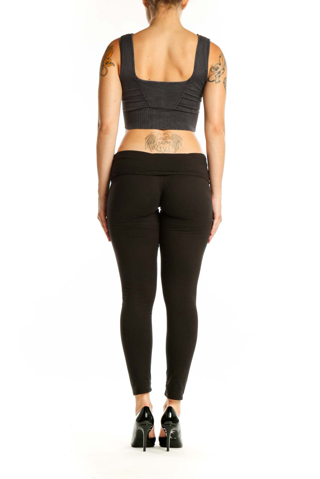 Black ribbed sports bra back view showing supportive design and cropped length on model