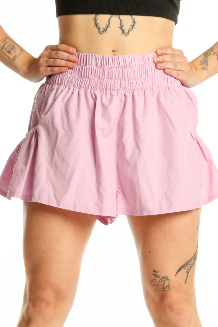 Pink pleated athletic skirt with smocked waistband, front view on model