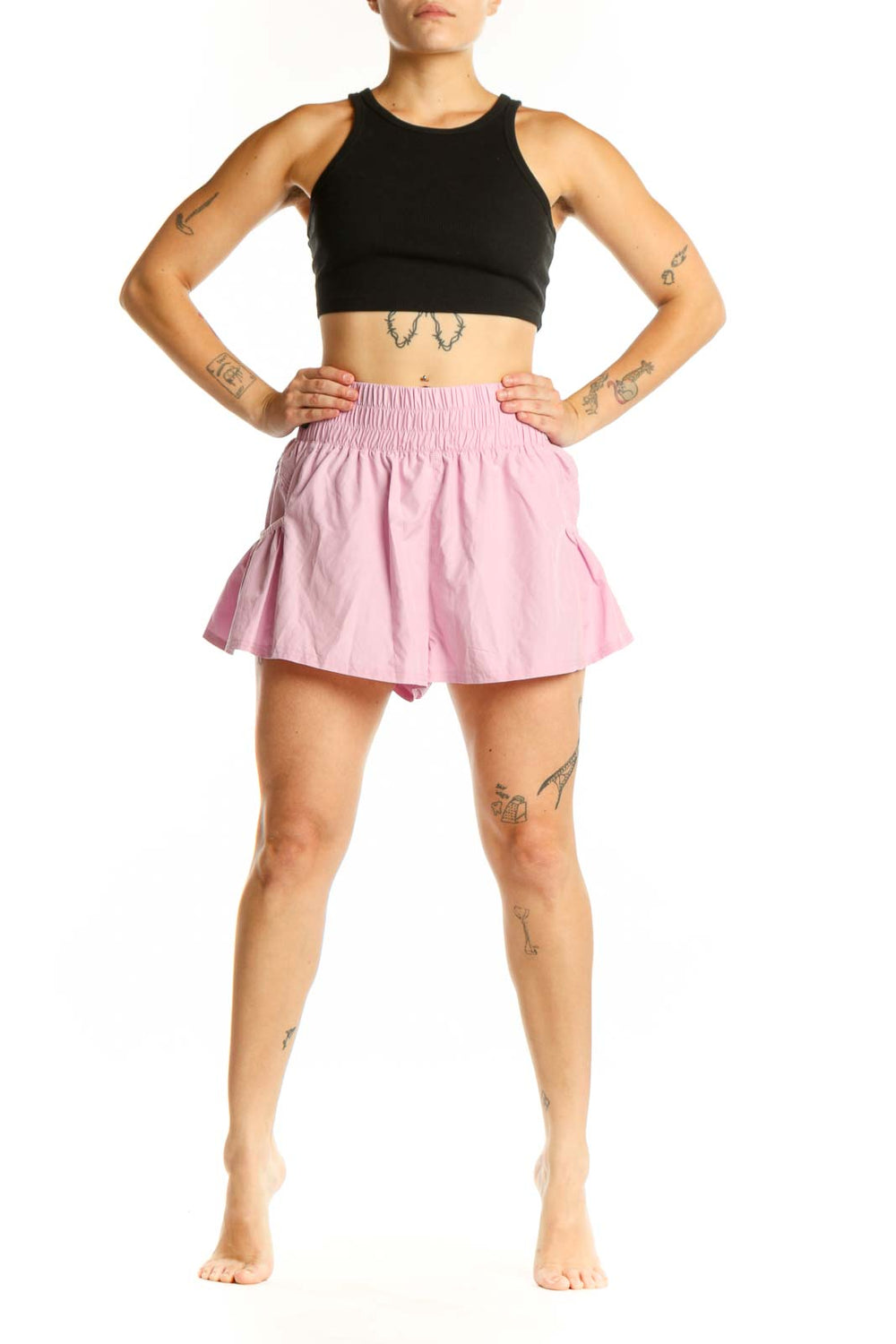 Pink pleated athletic skirt with smocked waistband, front view on model