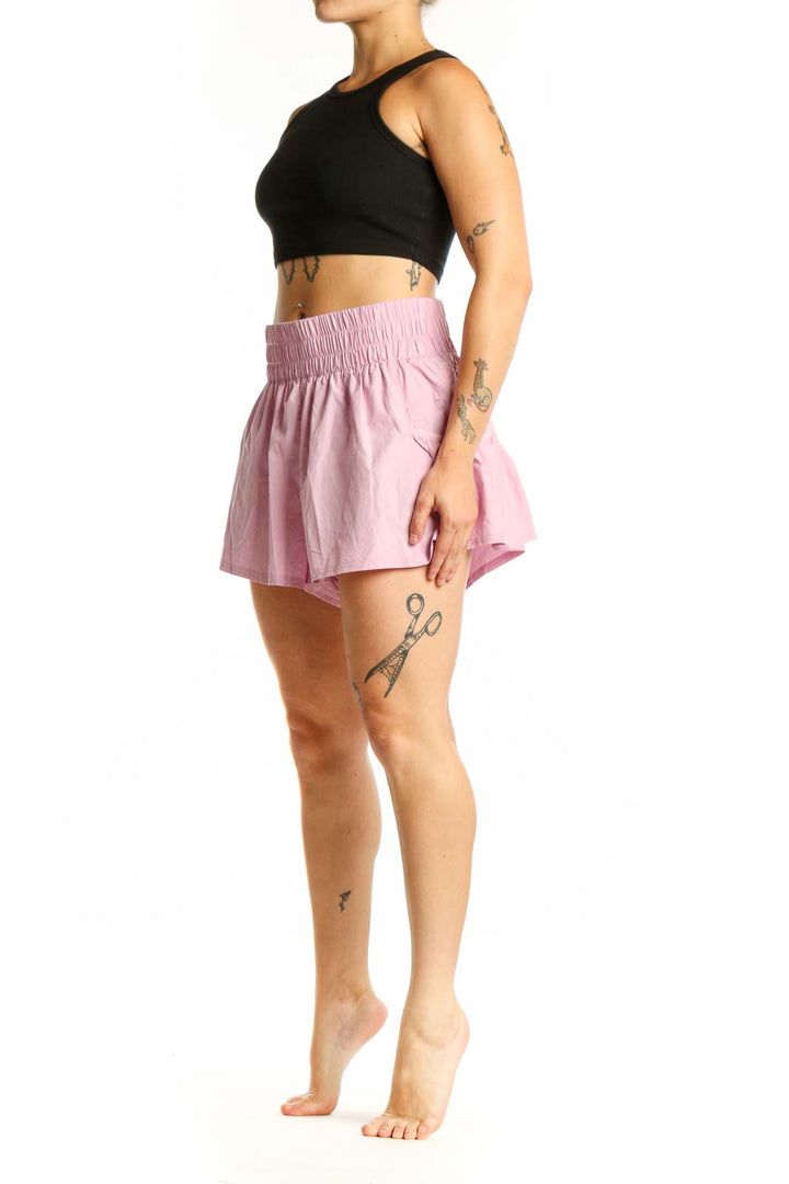 Pink pleated athletic skirt with smocked waistband, front view on model