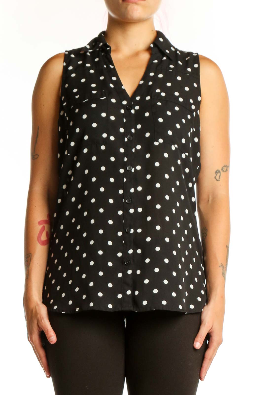 Black sleeveless button-up blouse with white polka dot pattern, front view