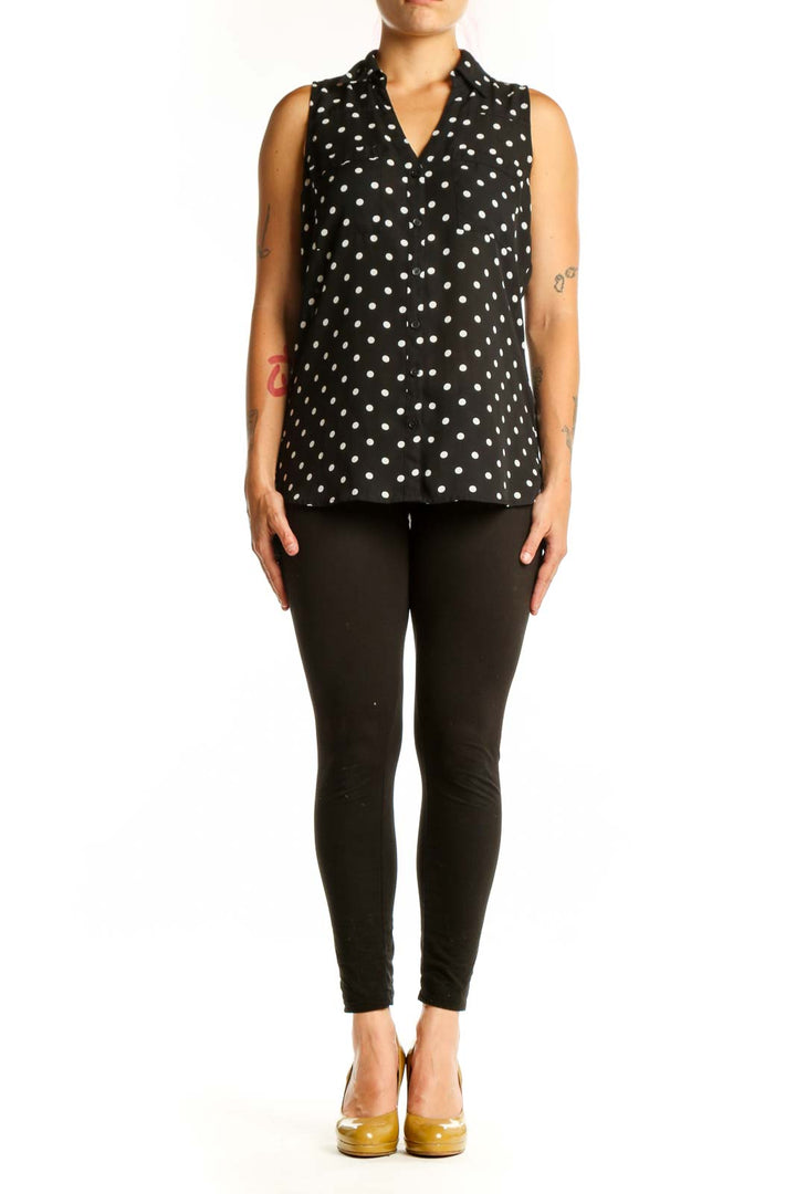 Black sleeveless button-up blouse with white polka dot pattern, front view