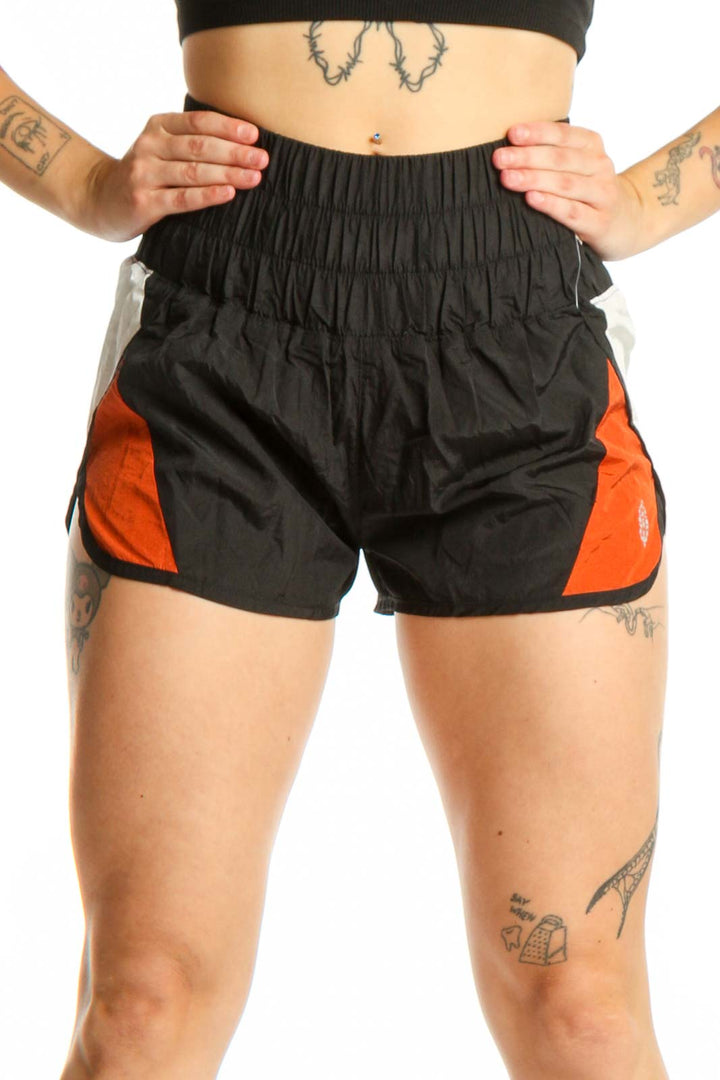 Black and orange colorblock athletic shorts with high-waisted ruched waistband and side pockets, front view