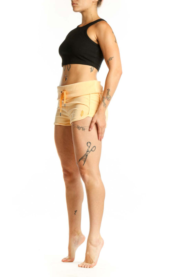 Yellow cotton activewear shorts with orange drawstring and ruched detailing, front view
