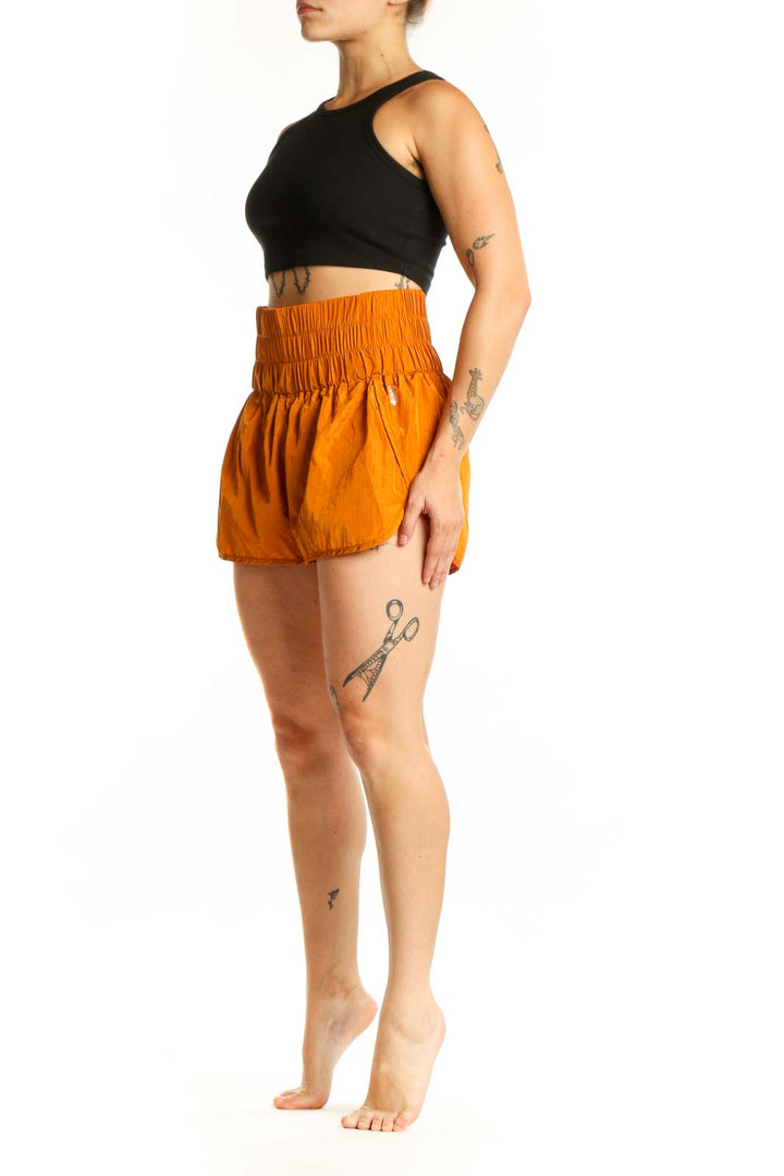 Front view of orange bubble shorts with high-waisted elasticated waistband and gathered hem detail