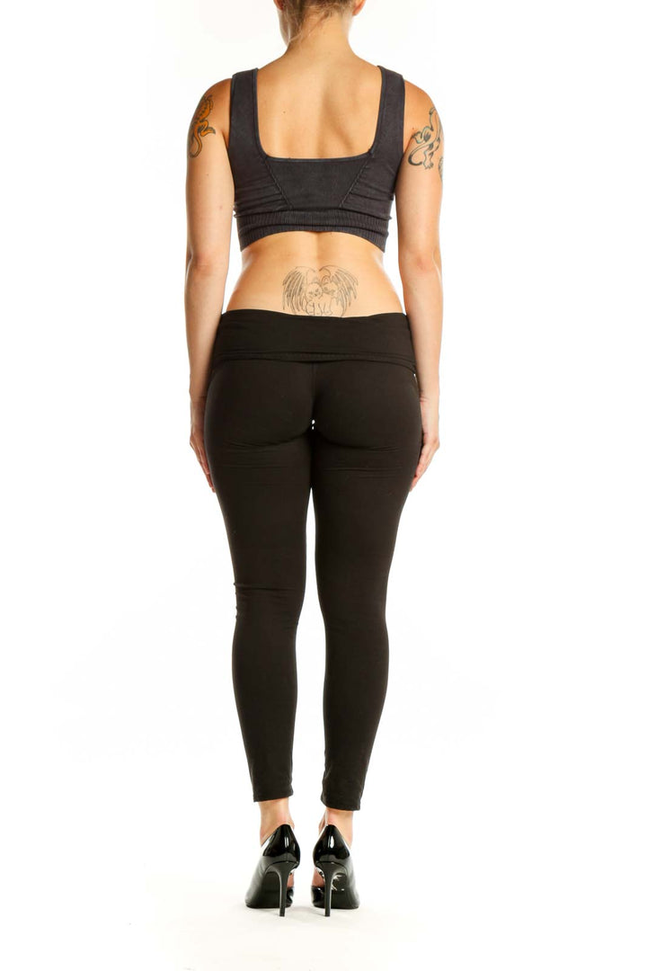 Black ribbed sports bra back view showing supportive design and fit on model