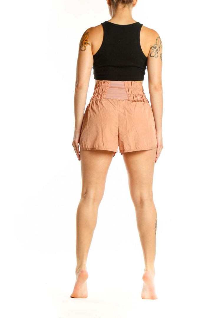 Peach high-waisted athletic shorts with relaxed fit, back view on model