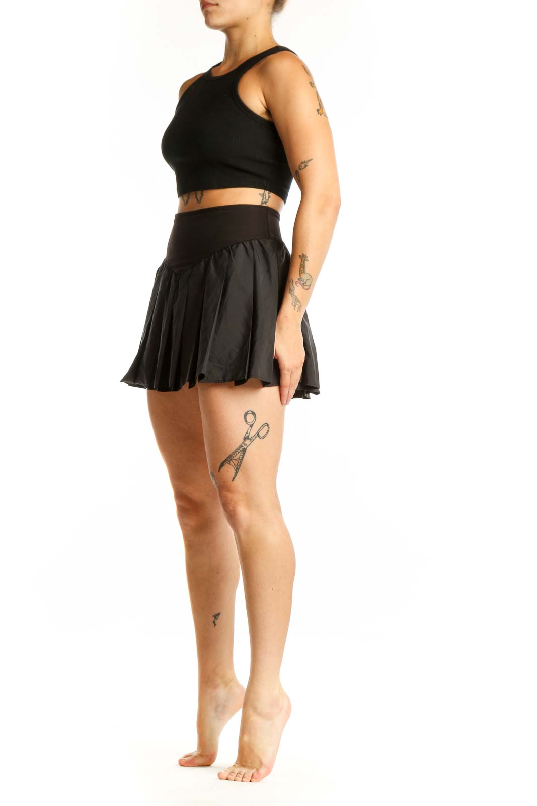 Black pleated athletic skirt with high waistband and built-in shorts, front view