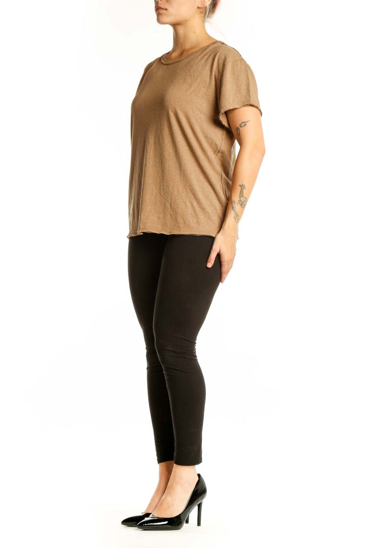 Woman wearing tan organic cotton crew neck t-shirt by WE THE FREE, front view