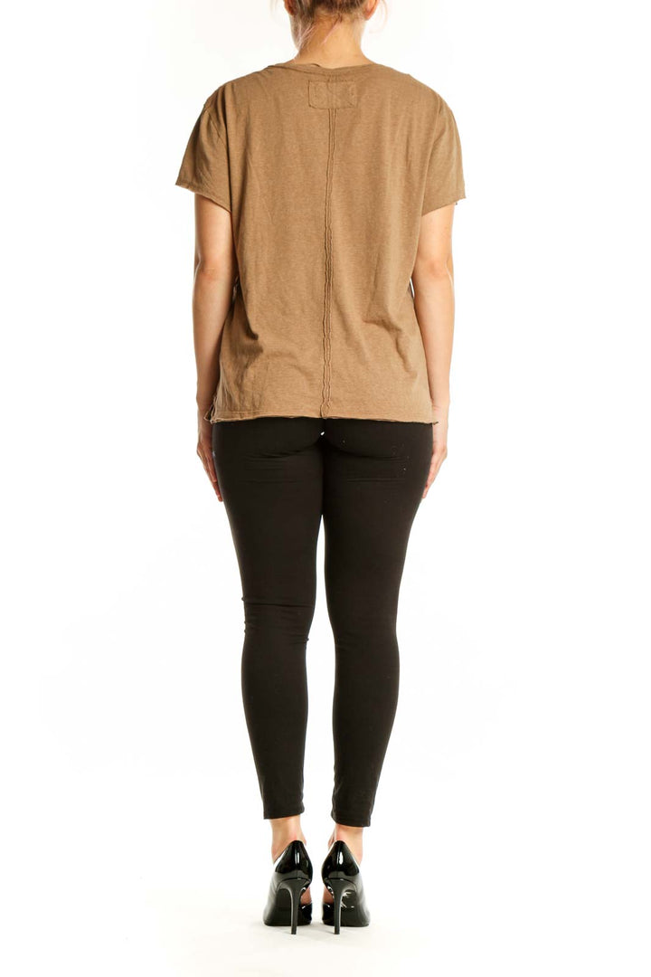 Woman wearing tan organic cotton crew neck t-shirt by WE THE FREE, back view with side profile