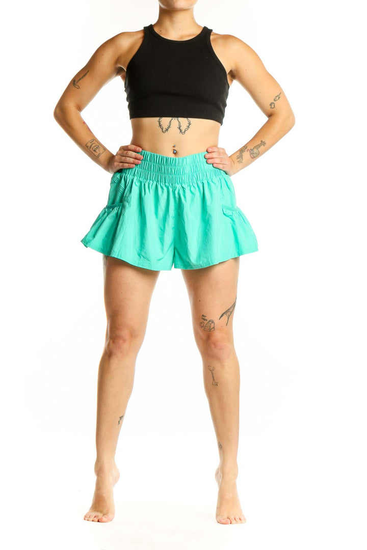 Mint green ruched athletic shorts with high waistband and flared hem, front view