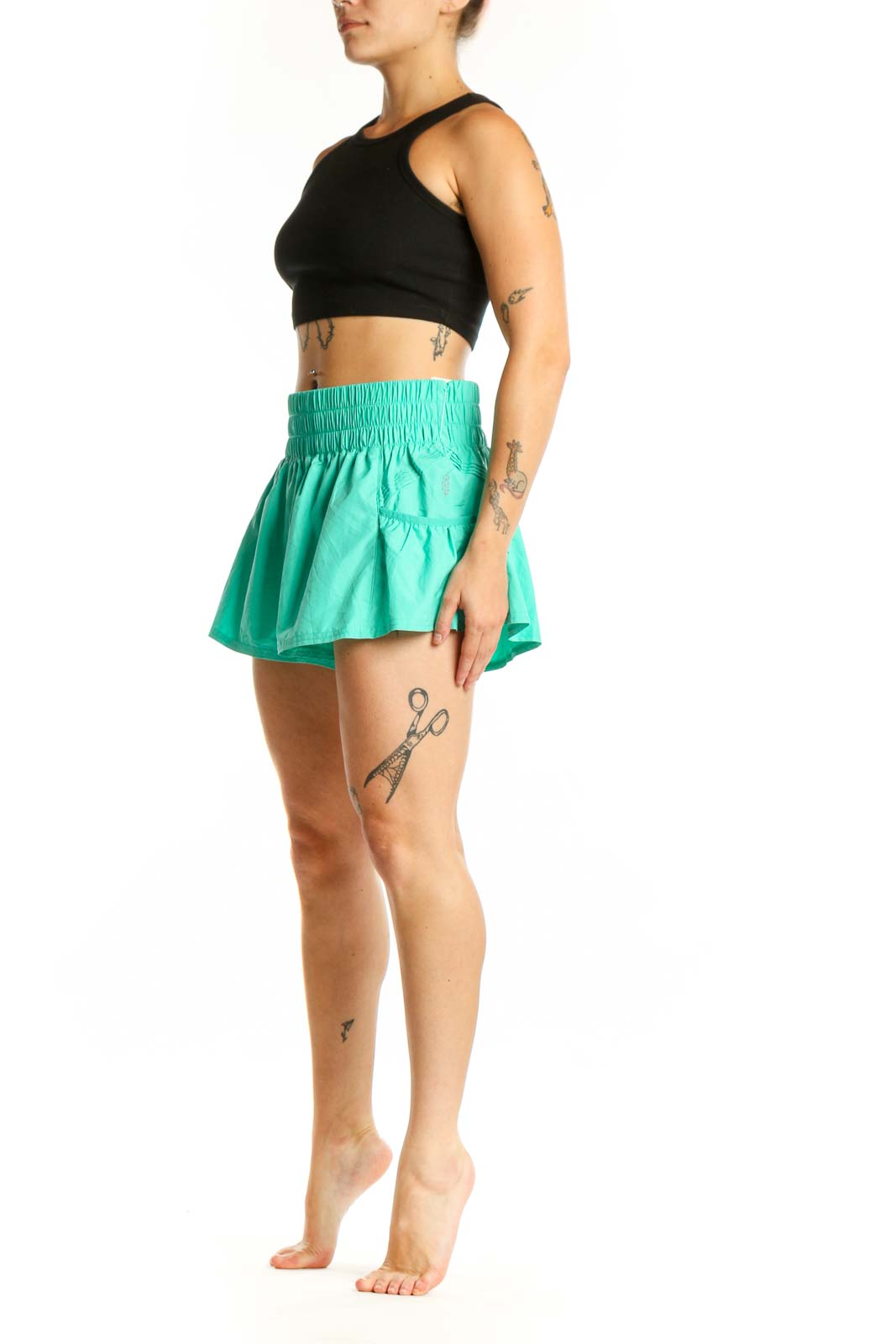 Mint green ruched athletic shorts with high waistband and flared hem, front view
