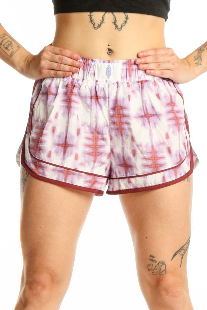 Front view of pink tie dye athletic shorts with burgundy trim by Free People Movement, size S