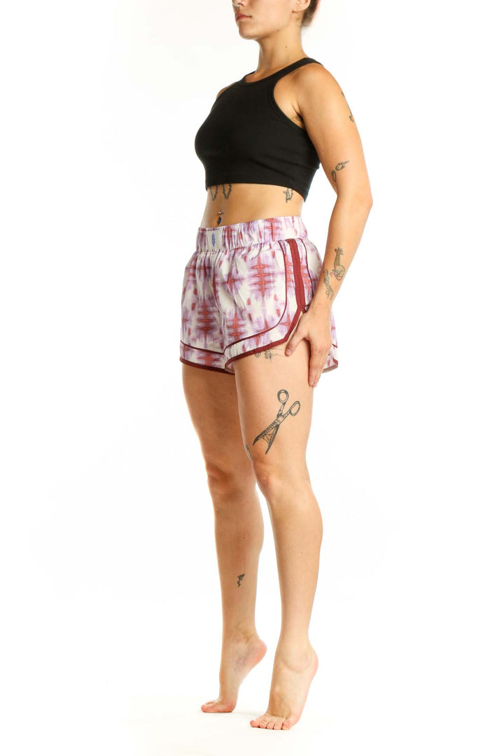 Front view of pink tie dye athletic shorts with burgundy trim by Free People Movement, size S