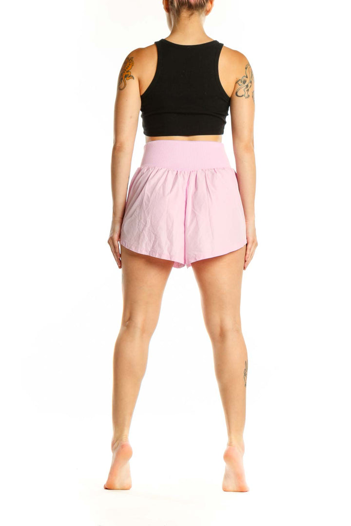 Pink ribbed waistband athletic shorts back view on model wearing black sports bra