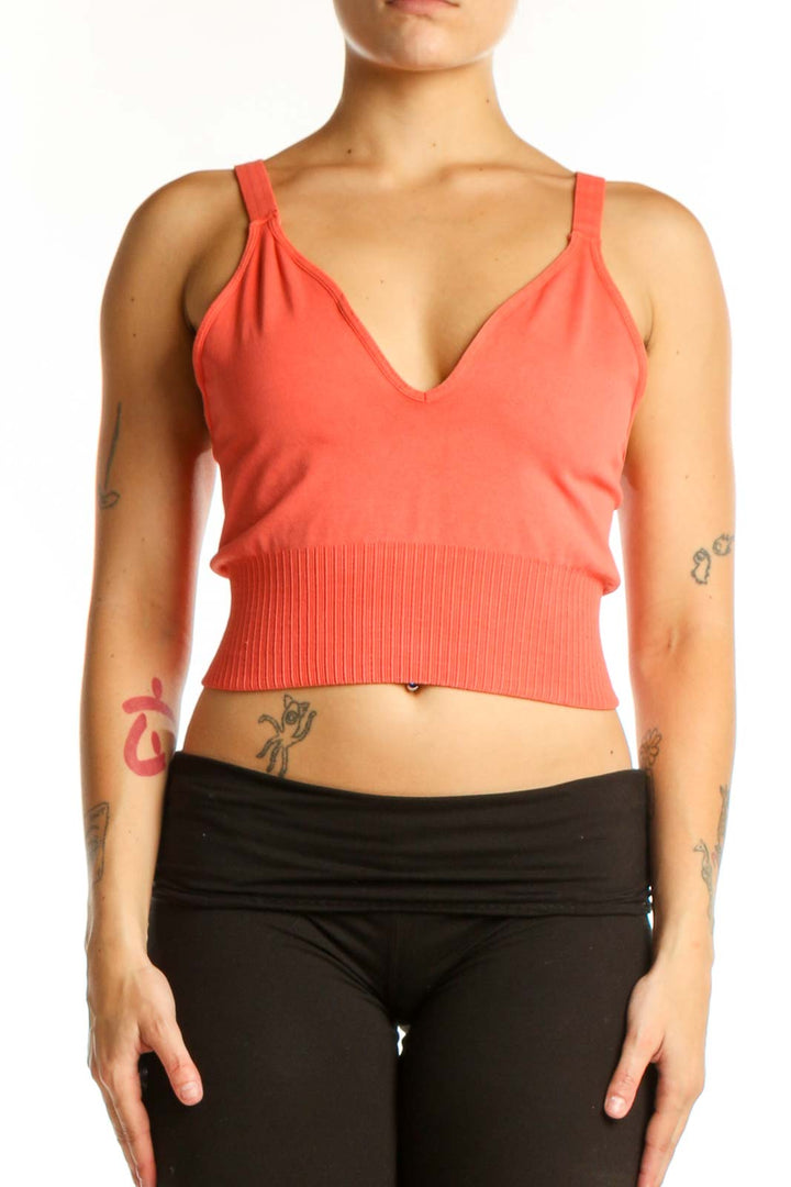 Coral ribbed crop tank top with V-neckline and black leggings, front view