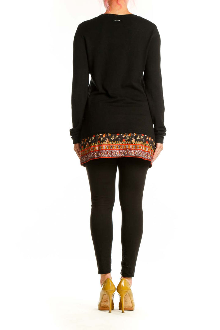 Back view of black Desigual cardigan showing floral embroidered hem and folk-inspired geometric border pattern