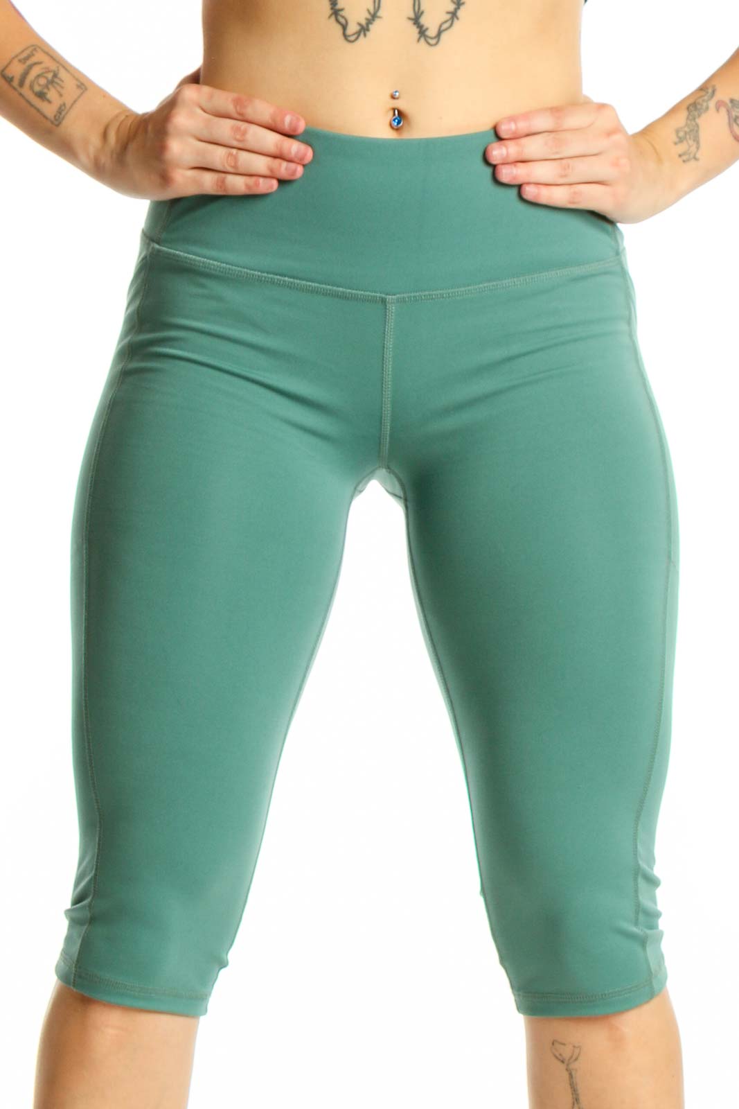 Woman wearing sage green high-waist capri leggings with black sports bra, front view