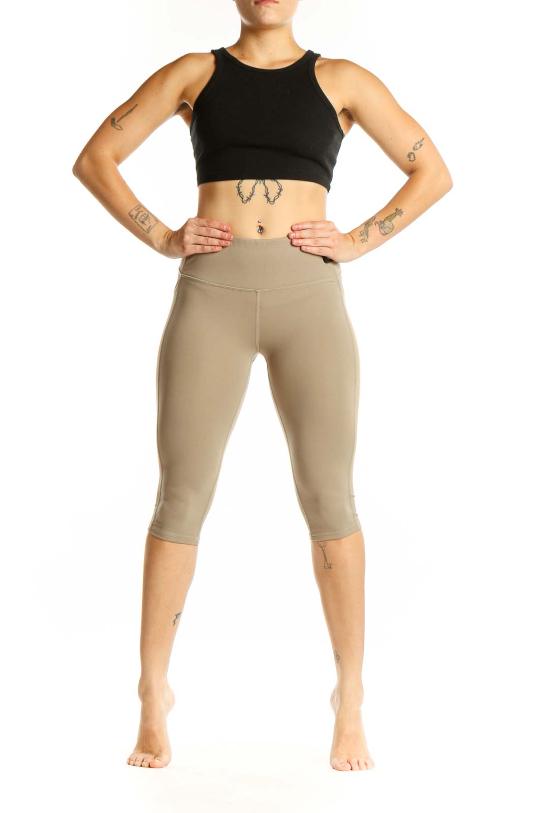 Woman wearing beige high-waist capri leggings with side pockets, front view
