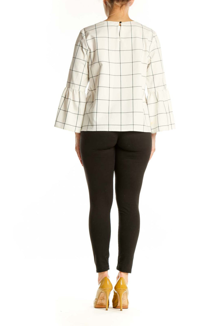 Cream grid print bell sleeve top with geometric pattern, back view on model